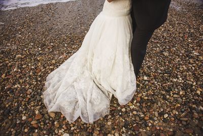 Low section of woman standing on pebbles