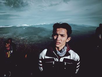 Portrait of man standing on mountain against sky