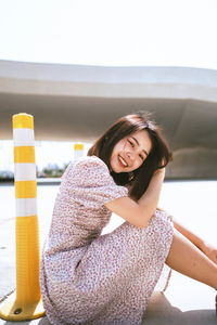 Portrait of a smiling young woman sitting outdoors