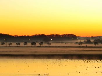 View of lake against orange sky