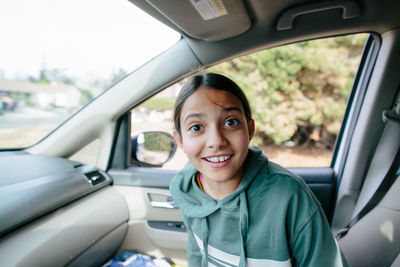 Girl smiles with a surprised expression while in the car