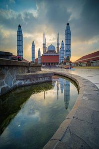 Reflection of buildings in city at dusk