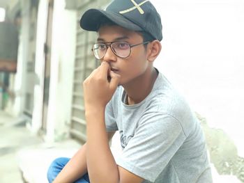 Portrait of boy sitting against wall