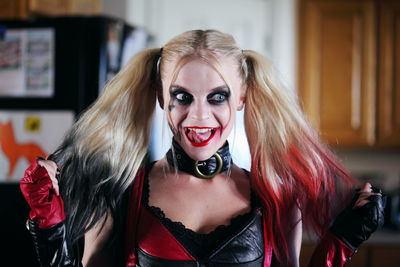 Happy woman with make-up holding long hair at home