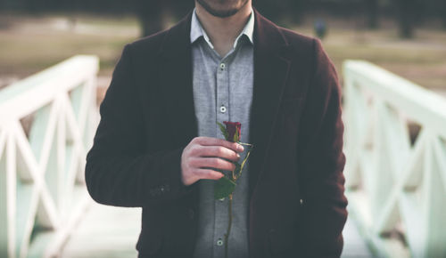 Midsection of man holding umbrella