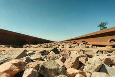 Close-up of rocks against clear blue sky