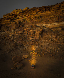 High angle view of illuminated car by rock formation at night