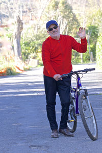 Full length of young man riding bicycle on road