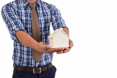 Midsection of man holding umbrella against white background