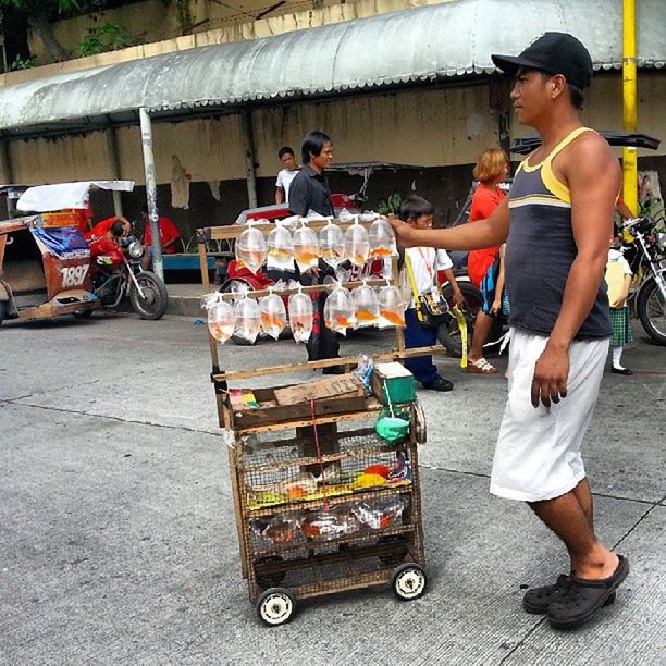 lifestyles, casual clothing, leisure activity, full length, food and drink, food, men, standing, retail, person, sitting, street, holding, outdoors, small business, for sale