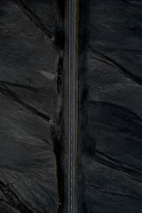 Aerial view of straight road surrounded by black landscape