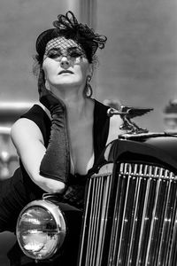 Monochrome portrait  of a stylish sophisticated lady in a vintage image posing near a retro car