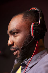 Side view of man looking away against black background