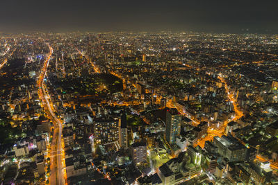 High angle view of illuminated cityscape against sky at night