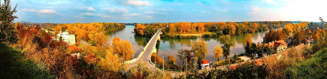 Panoramic view of tisza by autumn trees against sky