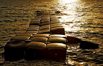 Stack of stones on beach against sky during sunset