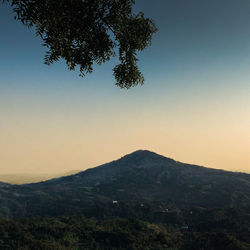 Scenic view of mountains against clear sky at sunset