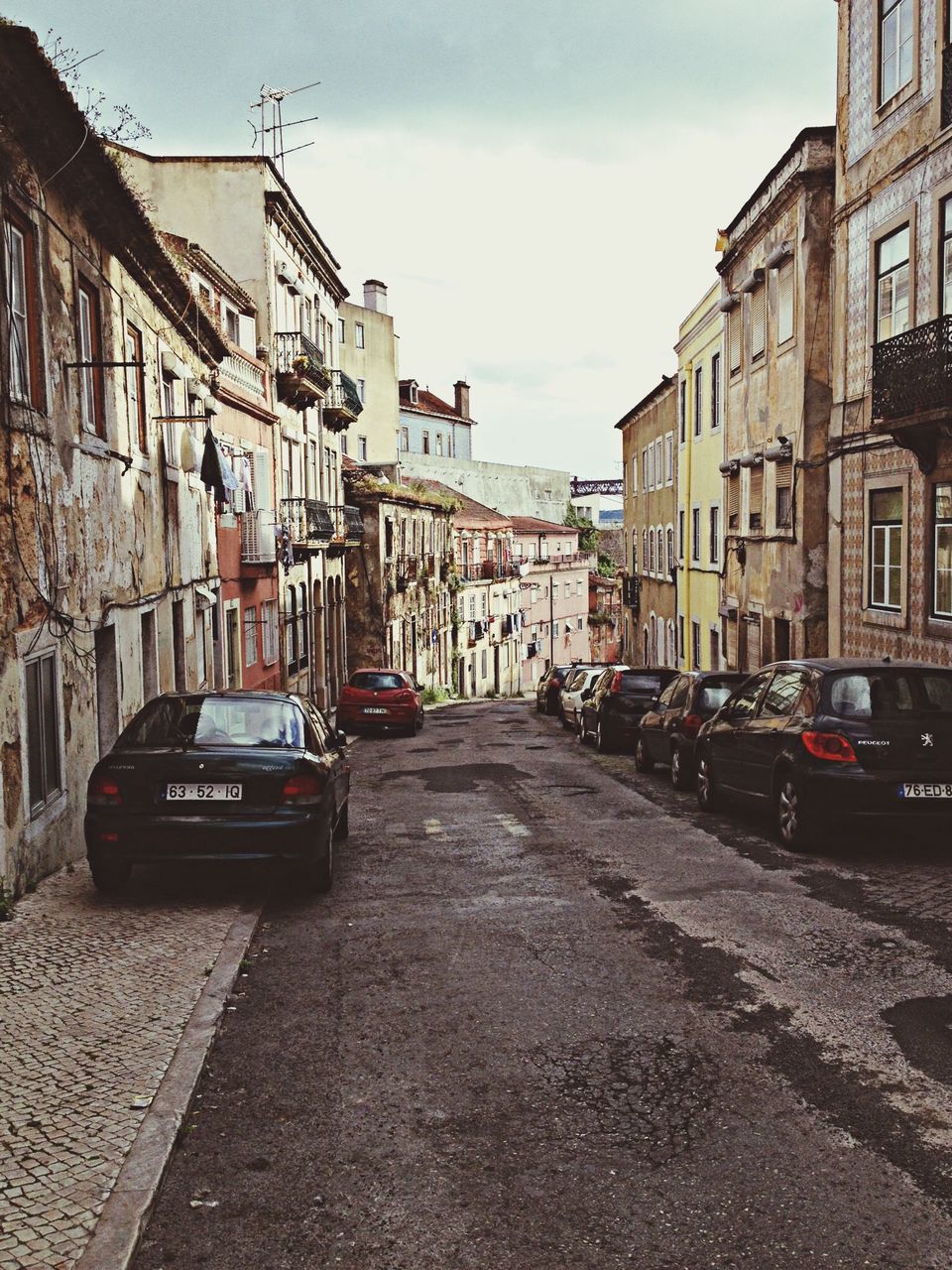 building exterior, architecture, transportation, built structure, car, street, land vehicle, city, mode of transport, road, sky, the way forward, city street, incidental people, city life, building, diminishing perspective, day, outdoors, travel