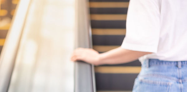 Midsection of woman standing by railing