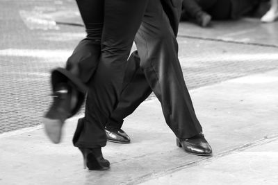 Low section of people walking on street in city