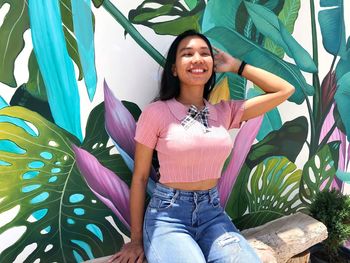 Portrait of smiling young woman sitting outdoors