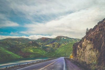 Road amidst mountains against sky