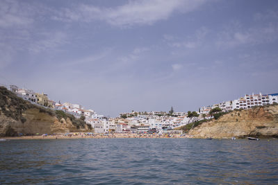 Scenic view of sea by town against sky