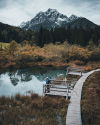 Senior man standing on pier by lake