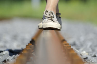 Low section of woman walking on railroad track