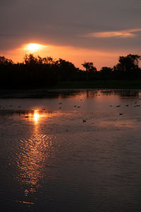 Scenic view of lake against orange sky
