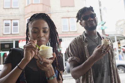A young man and woman eating frozen yoghurt.