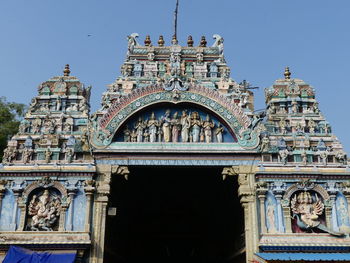 Low angle view of statue of historic building against sky