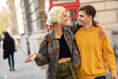 Smiling couple walking on street in city