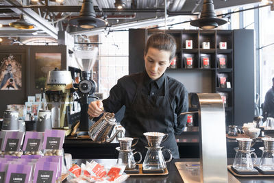 Female barista preparing coffee at counter