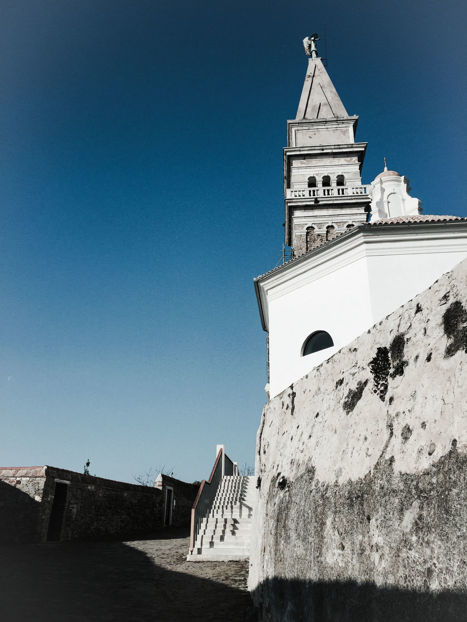 building exterior, architecture, built structure, clear sky, low angle view, blue, religion, place of worship, copy space, church, spirituality, tower, clock tower, history, sunlight, day, outdoors, no people