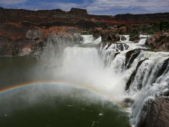 Scenic view of waterfall against sky