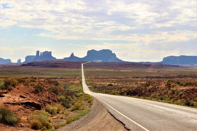 Empty road along landscape against sky