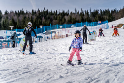 Full length of children on snow covered mountain