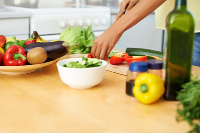 Cropped hand of man preparing food on table