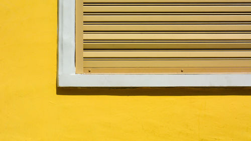 Close-up of window on yellow wall