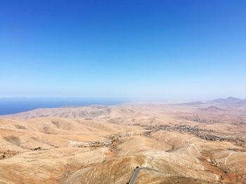 Scenic view of desert against clear blue sky