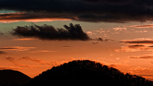Low angle view of silhouette trees against dramatic sky