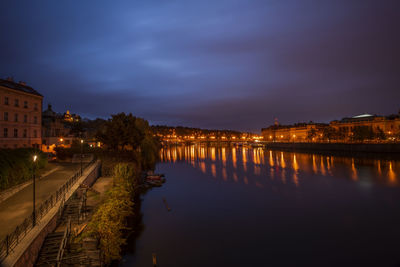 Illuminated bridge over river against sky at night