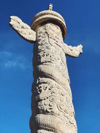 Low angle view of statue against blue sky