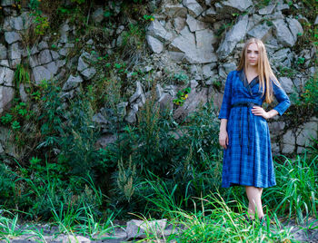 Portrait of young woman standing in grass