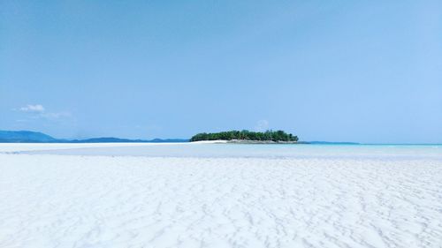 Scenic view of beach against clear blue sky