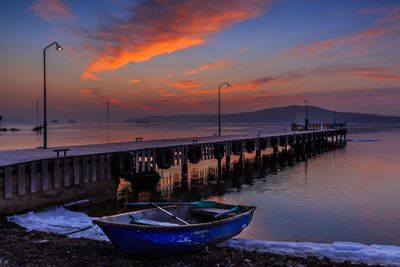 Pier on sea against sky during sunset