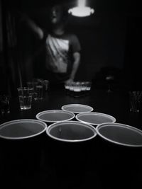 Person playing beer pong in darkroom