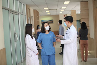 Doctor wearing mask discussing with patient at hospital