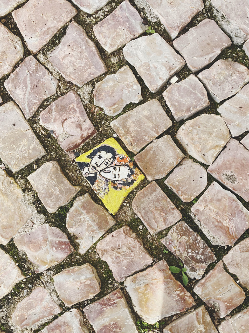 HIGH ANGLE VIEW OF PAVING STONES ON FOOTPATH